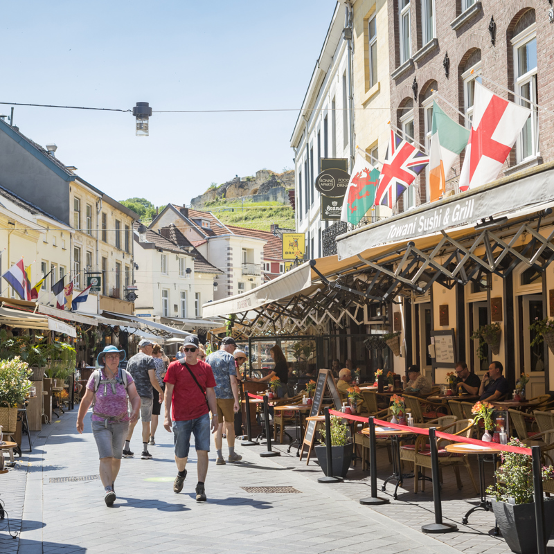 Straatbeeld Grotestraat met zicht op Kasteelruine in zomer in Valkenburg aan de Geul